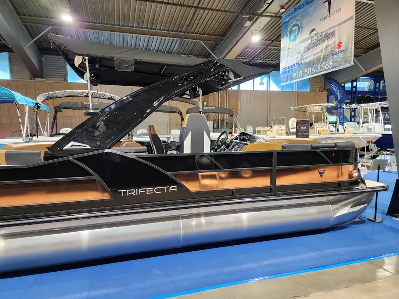 Slide: The Image of 2024 Trifecta 23 RF SS With Arch pontoon boat on display indoors. - 3