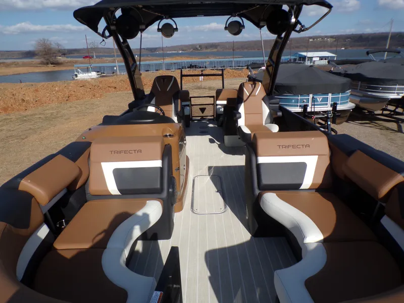 Slide: The Image of 2024 Trifecta 23 RF SS With Arch pontoon boat interior, docked near a lake. - 41