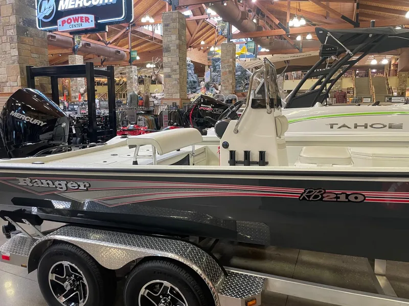 The Image of 2024 Ranger RB210 boat on trailer, parked on concrete, under clear blue sky. - 0