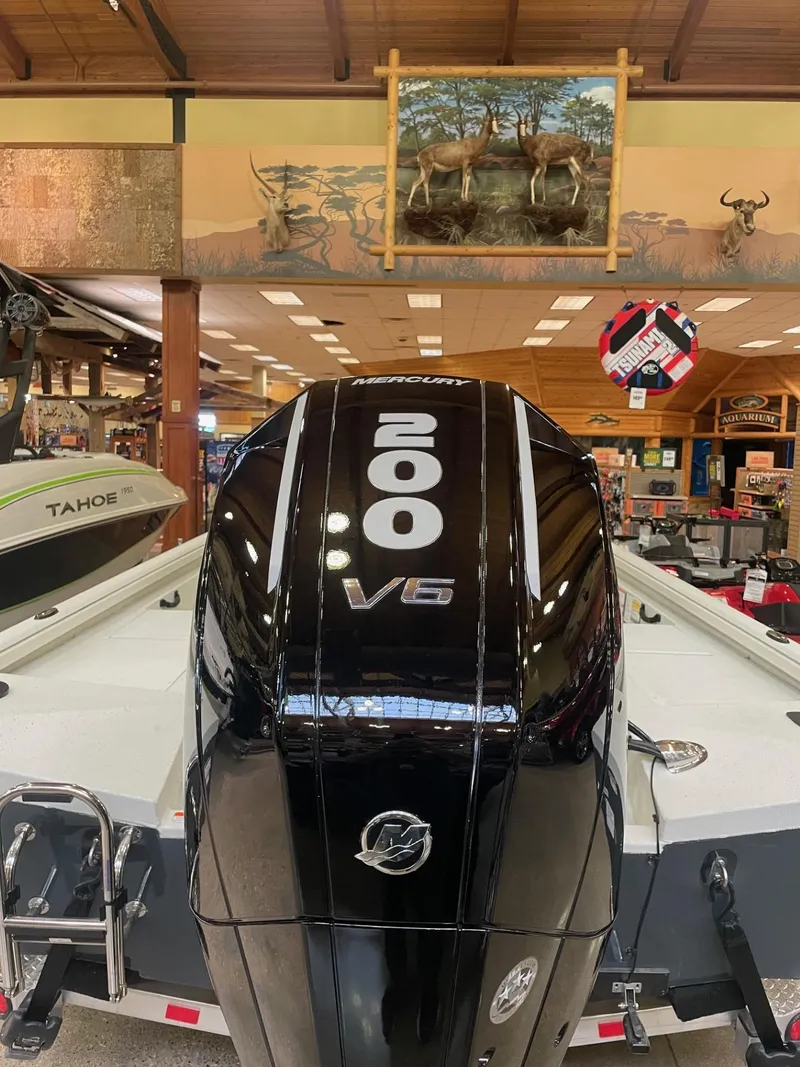 Slide: The Image of 2024 Ranger RB210 boat on trailer, parked on concrete, under clear blue sky. - 2