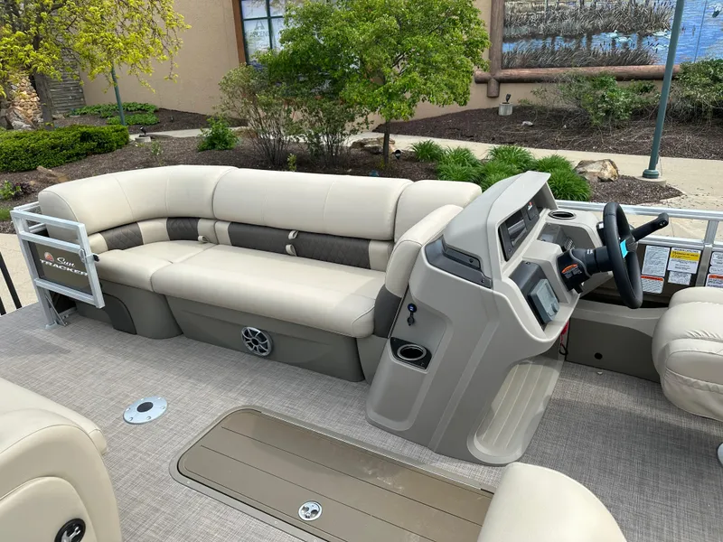 Slide: The Image of 2024 Sun Tracker SportFish 22 XP3 pontoon boat interior with beige seating and control console. - 4