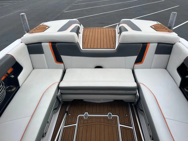 Slide: The Image of 2013 Nautique G23 boat interior with white and gray seating, teak flooring. - 11