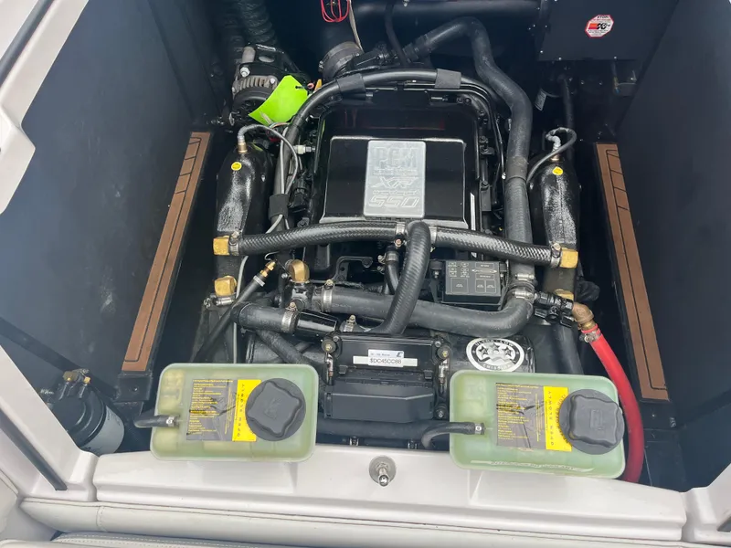 Slide: The Image of 2013 Nautique G23 engine compartment with dual coolant reservoirs and detailed engine components. - 12