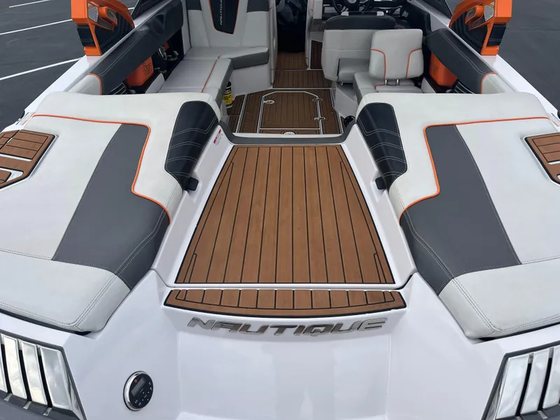 Slide: The Image of 2013 Nautique G23 boat interior with teak flooring and cushioned seating. - 13