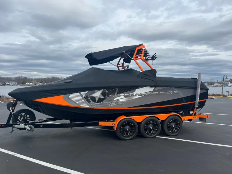 Slide: The Image of 2013 Nautique G23 boat with cover on trailer in parking lot. - 14