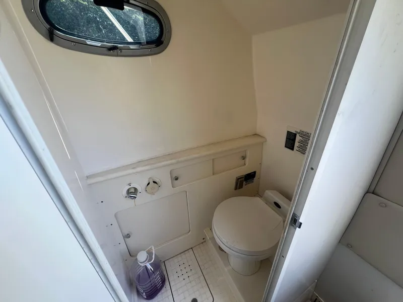 Slide: The Image of Compact marine bathroom in 2003 Boston Whaler 290 Outrage boat with toilet and small window. - 15