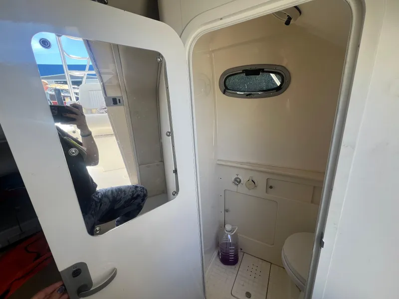 Slide: The Image of 2003 Boston Whaler 290 Outrage boat interior bathroom with window and door. - 16
