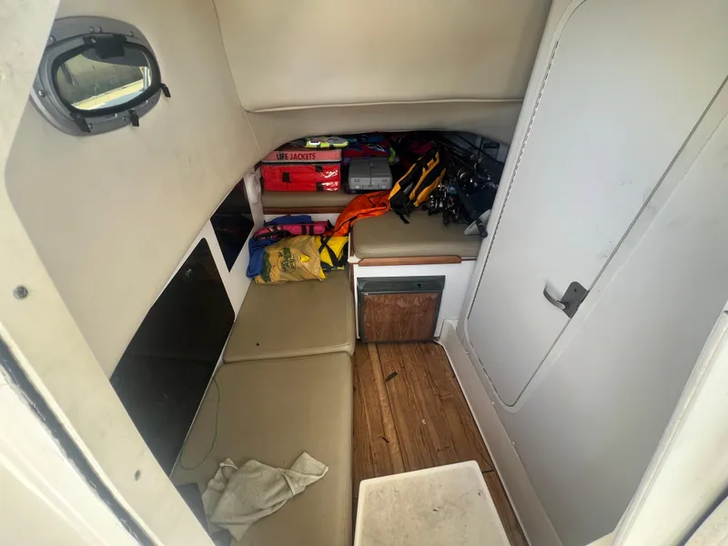 Slide: The Image of 2003 Boston Whaler 290 Outrage cabin interior with storage and seating. - 17