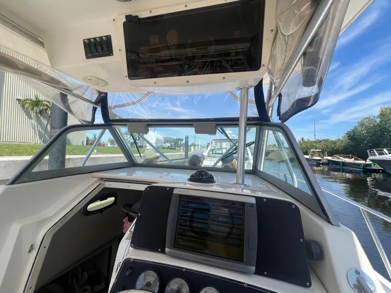 Slide: The Image of 2003 Boston Whaler 290 Outrage boat cockpit with navigation system and clear canopy. - 5