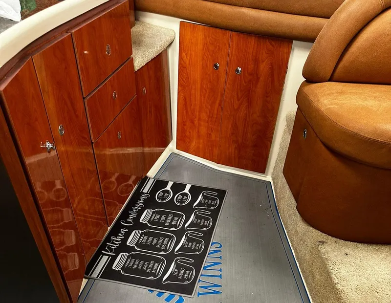 Slide: The Image of 2006 Four Winns 328 Vista interior with wooden cabinets and leather seating. - 28