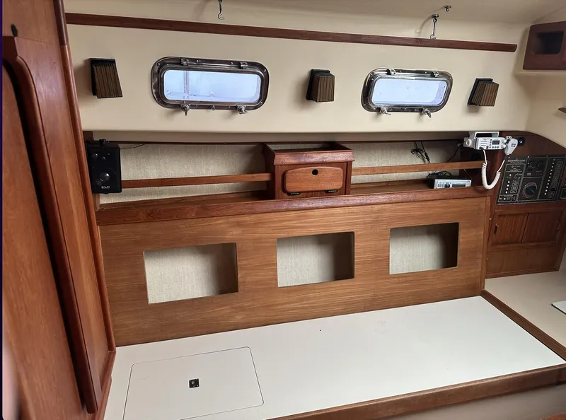 Slide: The Image of Interior of 1990 Island Packet 27 sailboat with wooden cabinetry and portholes. - 16