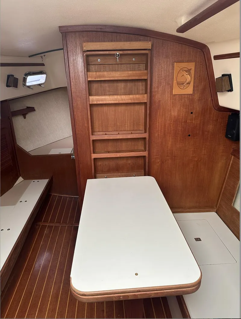Slide: The Image of 1990 Island Packet 27 interior with wooden cabinetry and foldable table. - 18