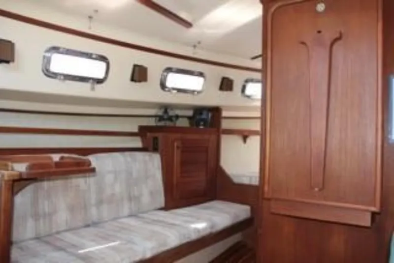 Slide: The Image of Interior of 1990 Island Packet 27 sailboat with wooden finish and seating area. - 5