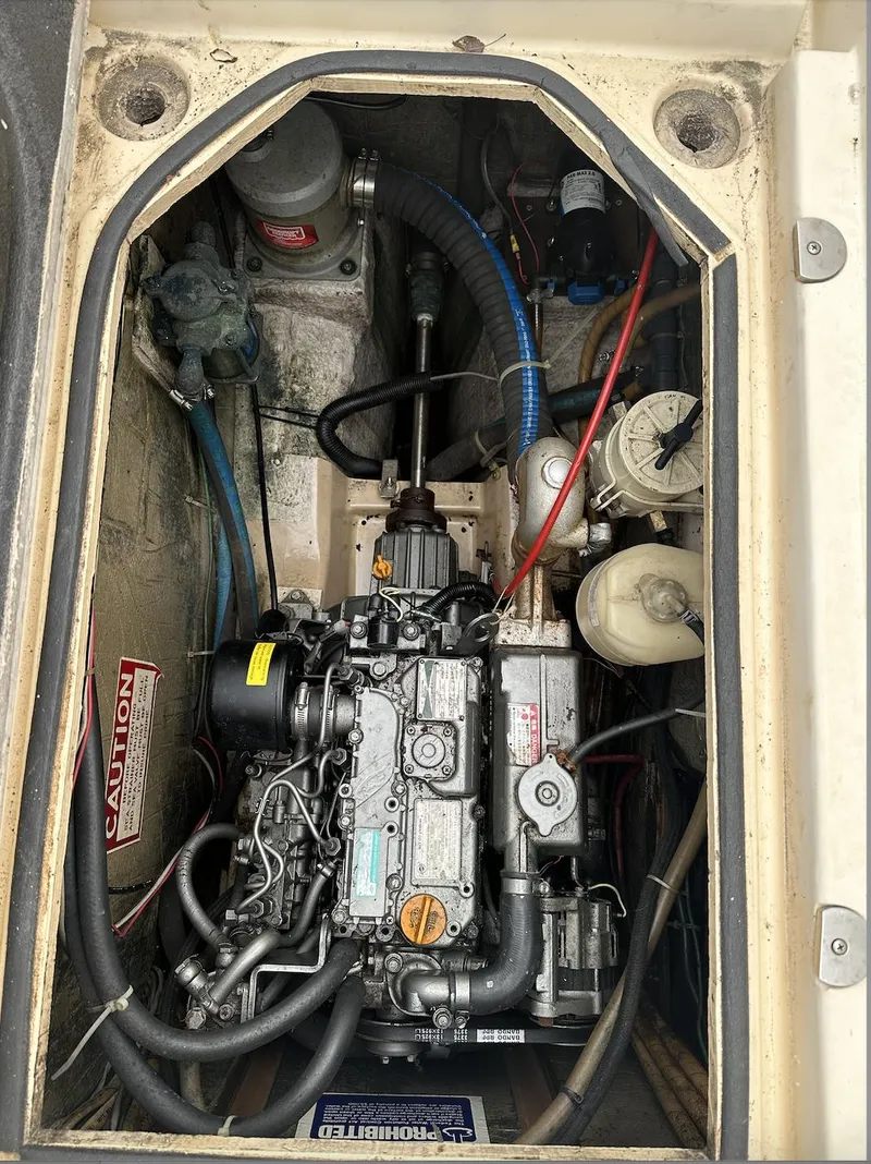 Slide: The Image of Engine compartment of a 1990 Island Packet 27 sailboat, showcasing mechanical components. - 9