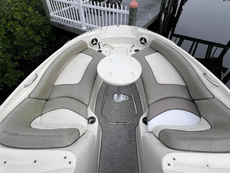 Slide: The Image of Sea Ray 240 Sundeck 2007 boat interior with 2023 motor, featuring spacious seating and table. - 12