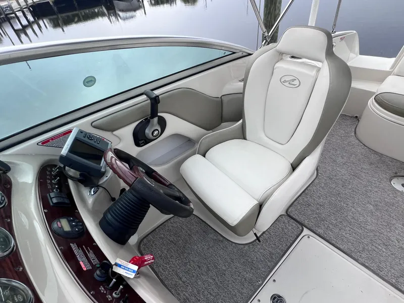 Slide: The Image of 2007 Sea Ray 240 Sundeck cockpit with 2023 motor, featuring helm seat and steering wheel. - 9