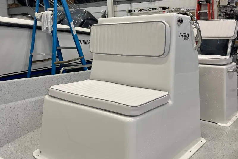 Slide: The Image of 2024 Maritime 1480 Skiff boat interior with cushioned seating in a service center. - 6