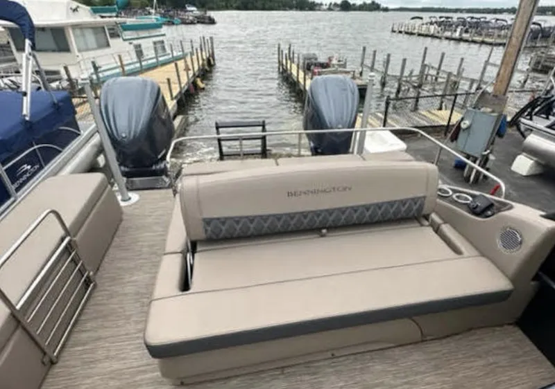 Slide: The Image of 2022 Bennington 27 QX boat with dual outboard motors docked at a marina. - 4