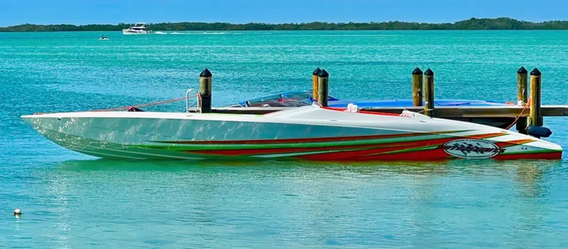 Slide: The Image of 2015 Outerlimits SL-50 speedboat docked in turquoise waters. - 2