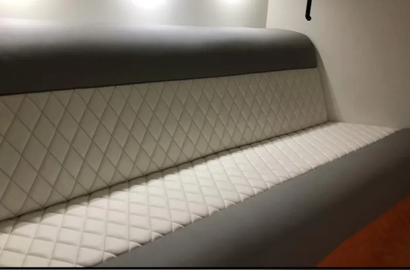 Slide: The Image of 2015 Outerlimits SL-50 boat interior with quilted white and gray seating. - 34