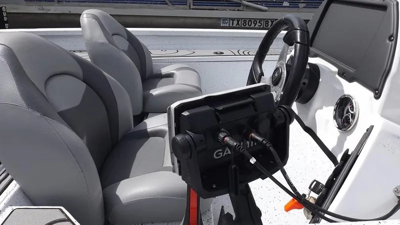 Slide: The Image of 2021 Xpress XP7 boat interior with Garmin navigation system and gray seats. - 11