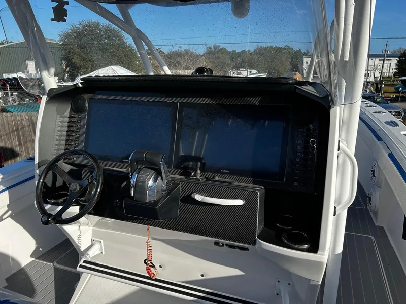 Slide: The Image of 2022 Nor-Tech 392 Superfish boat dashboard with steering wheel and control panel. - 14