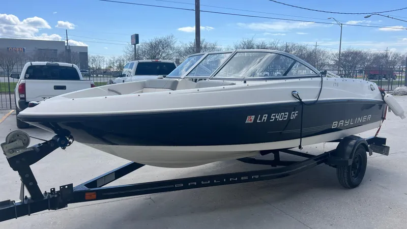 Slide: The Image of 2012 Bayliner 175 Bowrider boat on a trailer in a parking lot. - 11