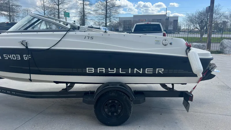 Slide: The Image of 2012 Bayliner 175 Bowrider boat on a trailer in a parking lot. - 12