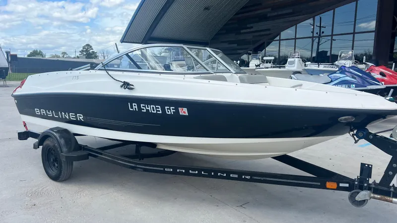 Slide: The Image of 2012 Bayliner 175 Bowrider boat on a trailer, parked outdoors. - 8