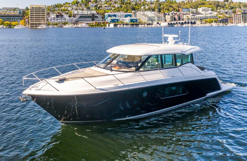 Slide: The Image of 2020 Tiara Yachts 49 COUPE cruising on a scenic waterfront. - 0