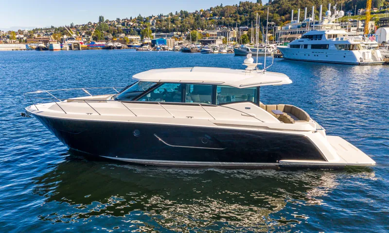 Slide: The Image of 2020 Tiara Yachts 49 COUPE luxury boat on water with marina background. - 1