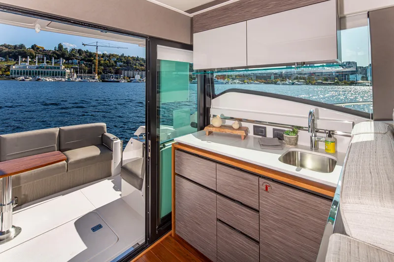 Slide: The Image of 2020 Tiara Yachts 49 COUPE kitchen and outdoor seating area with waterfront view. - 13