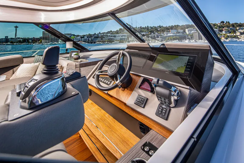 Slide: The Image of 2020 Tiara Yachts 49 COUPE helm station with modern navigation equipment and waterfront view. - 14