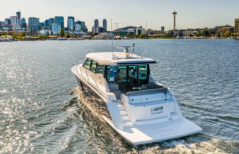 Slide: The Image of 2020 Tiara Yachts 49 COUPE cruising near city skyline and iconic tower. - 2