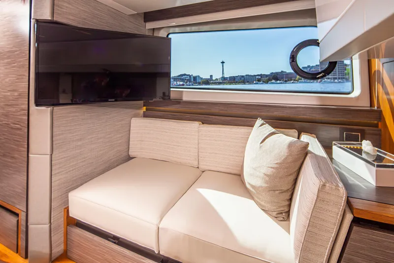 Slide: The Image of 2020 Tiara Yachts 49 COUPE interior with sofa, TV, and window view. - 24