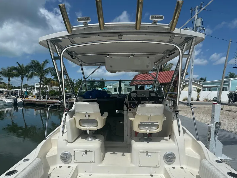 Slide: The Image of 2002 Seamaster 2800 Walkaround boat docked, rear view with seating and helm. - 25