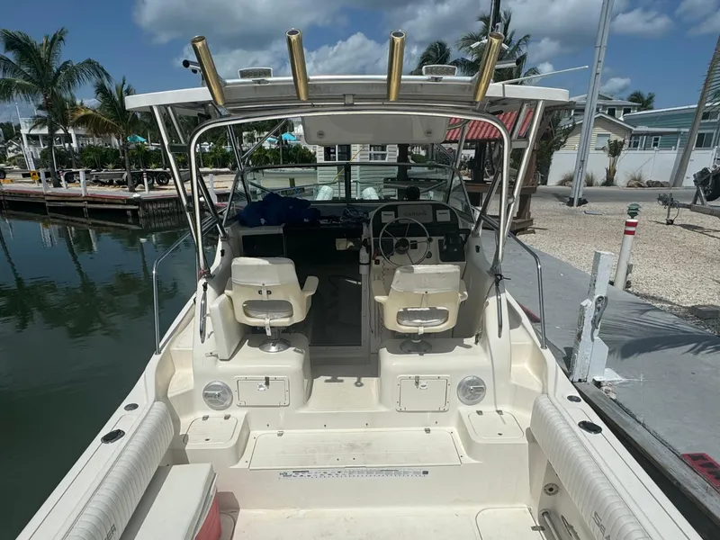 Slide: The Image of 2002 Seamaster 2800 Walkaround boat docked at a marina, view of the cockpit and seating. - 26