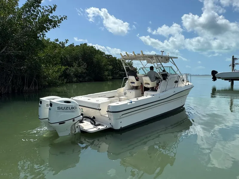 Slide: The Image of 2002 Seamaster 2800 Walkaround boat with Suzuki outboard motor on calm water. - 3