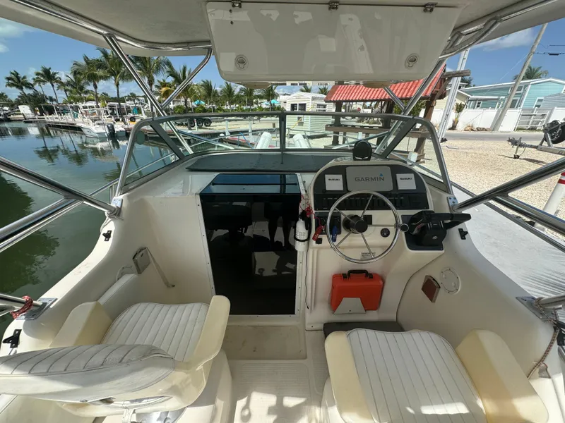 Slide: The Image of 2002 Seamaster 2800 Walkaround boat cockpit with steering wheel and seating. - 30