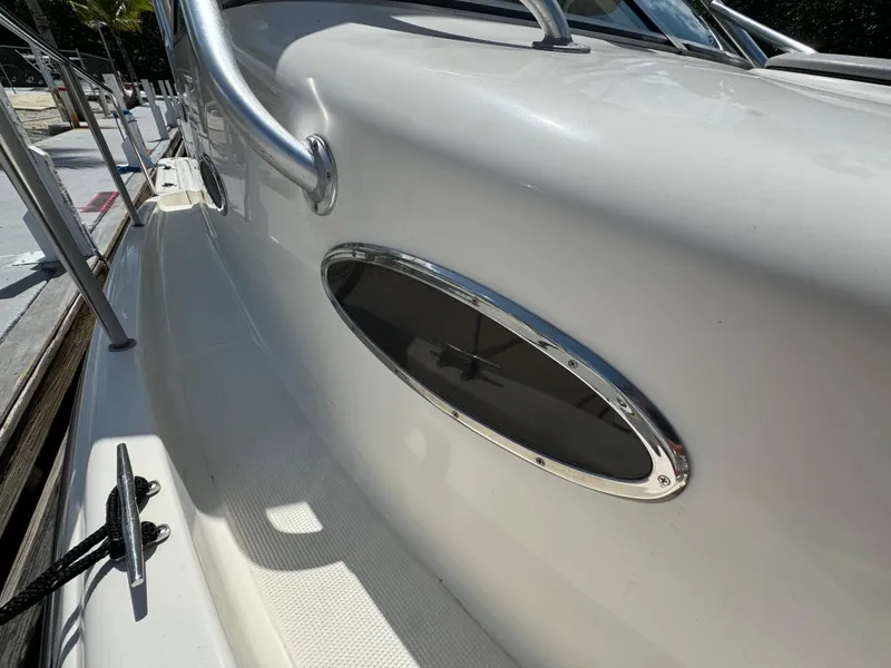 Slide: The Image of 2002 Seamaster 2800 Walkaround boat exterior detail with oval window and railing. - 41