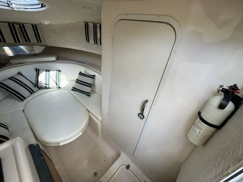 Slide: The Image of Interior cabin of a 2002 Seamaster 2800 Walkaround boat with seating and a fire extinguisher. - 46