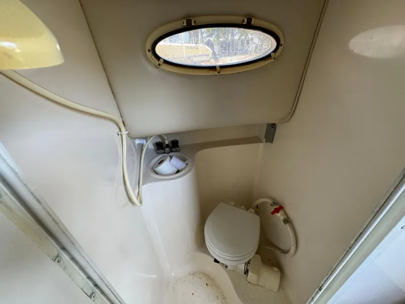 Slide: The Image of Compact bathroom in 2002 Seamaster 2800 Walkaround boat with toilet and small sink. - 49