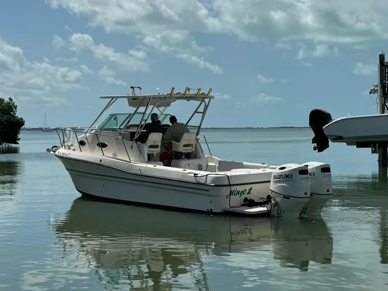 Slide: The Image of 2002 Seamaster 2800 Walkaround boat with Suzuki outboard motors on calm water. - 6