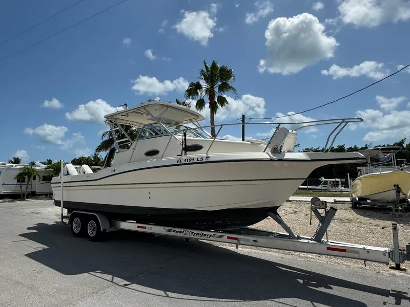 Slide: The Image of 2002 Seamaster 2800 Walkaround boat on trailer under sunny sky. - 7