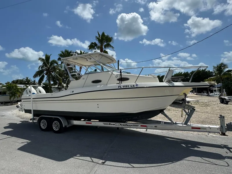 Slide: The Image of 2002 Seamaster 2800 Walkaround boat on trailer under sunny sky. - 8