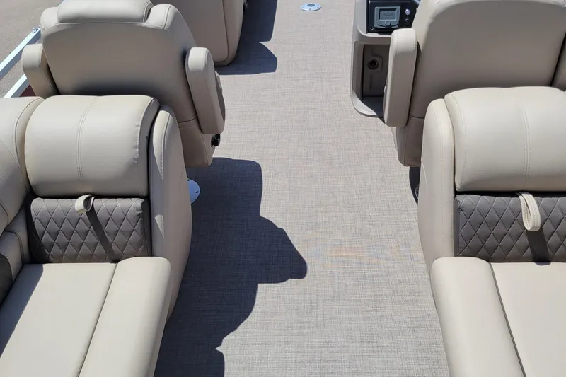 Slide: The Image of 2024 Sun Tracker Party Barge 24 DLX interior with beige seating and carpeted floor. - 4