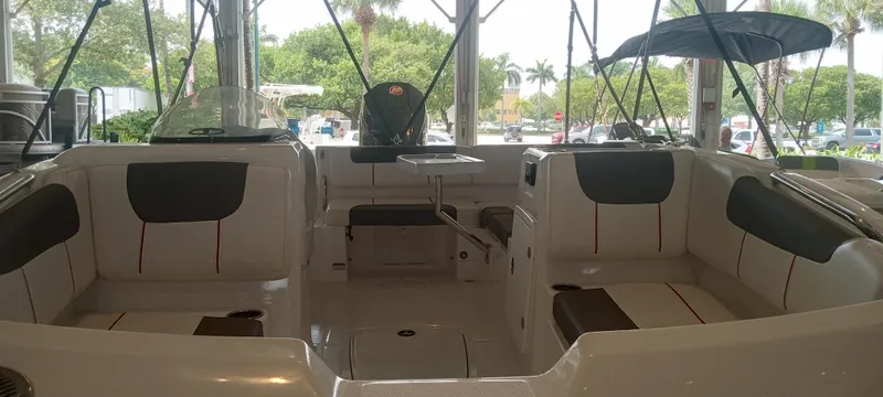 Slide: The Image of 2024 Tahoe 1950 boat interior with seating and canopy in showroom. - 2