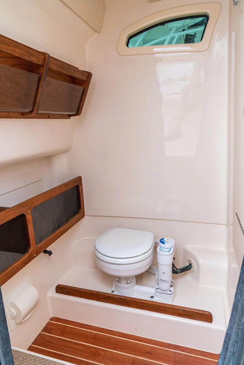 Slide: The Image of 2024 Grady-White 281 boat interior bathroom with toilet and wooden accents. - 7