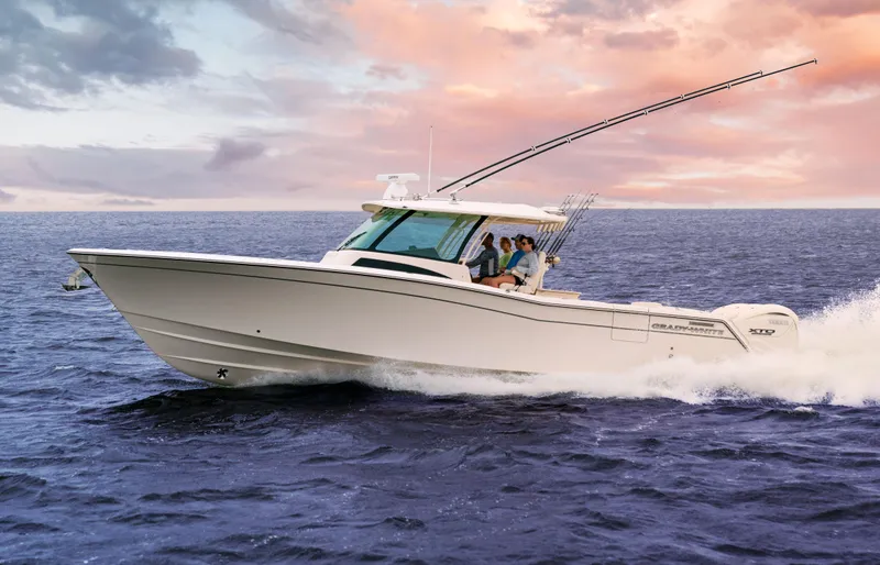 The Image of 2024 Grady-White 386 Canyon boat cruising on open water at sunset. - 1