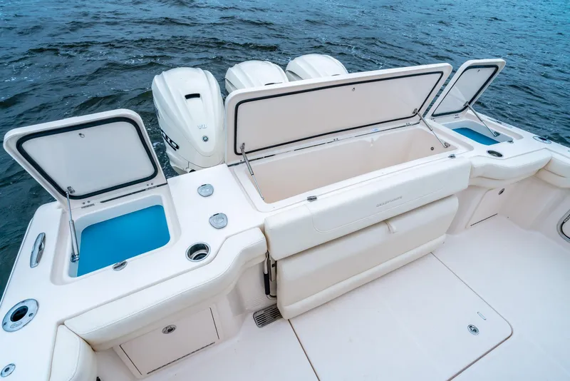 Slide: The Image of 2024 Grady-White 386 Canyon boat with open storage compartments and triple outboard engines. - 6